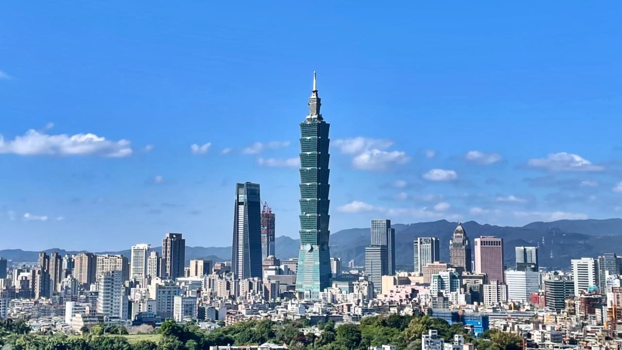 Taipei skyline with the Taipei 101 skyscraper standing out over the city under a clear blue sky